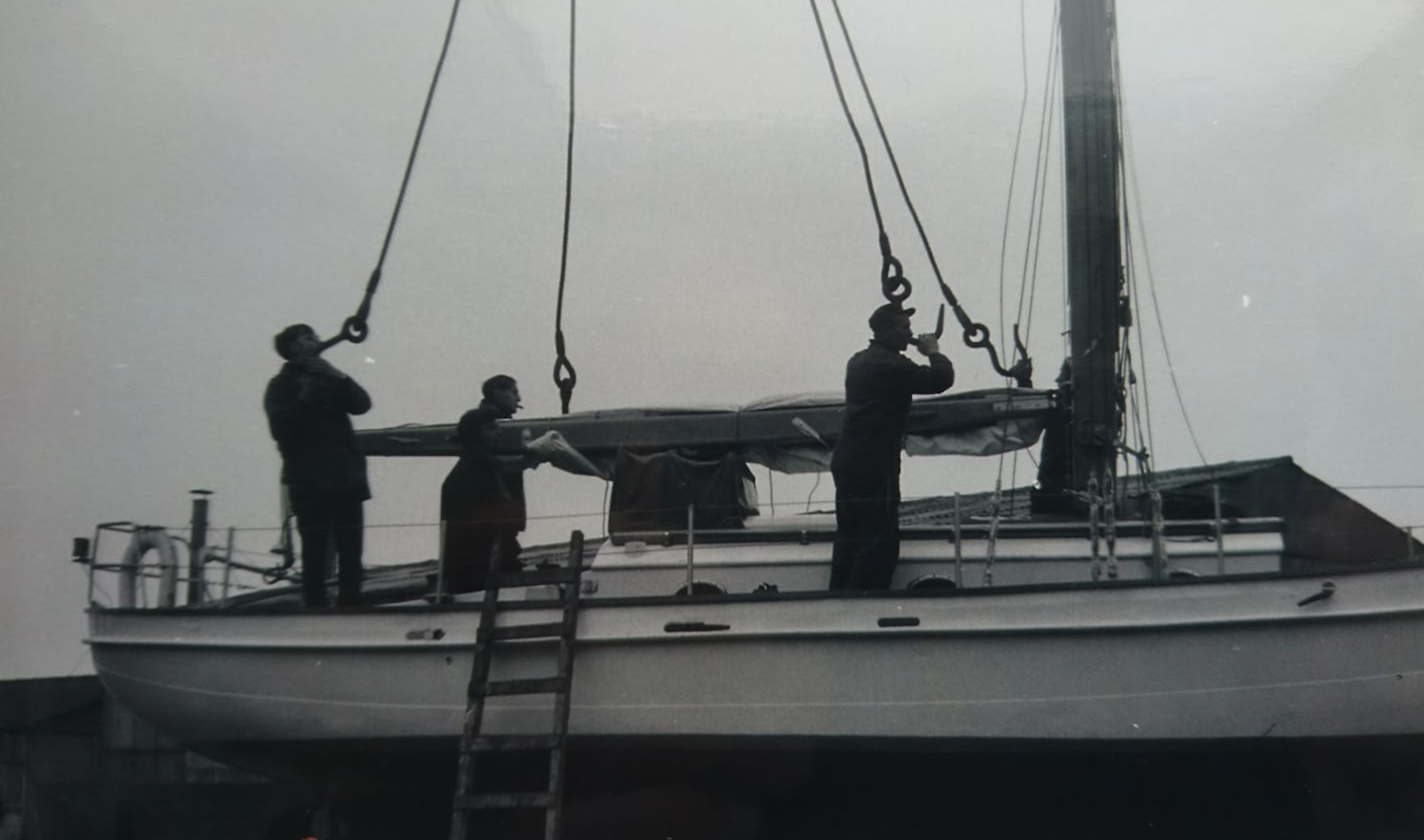 Bries in crane slings with three men on deck