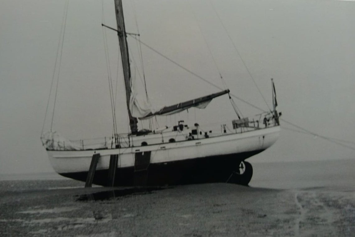 Bries dried out on beaching legs on a tidal flat, sails furled