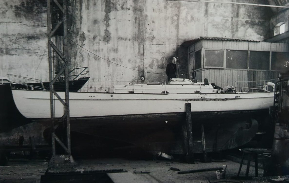 Bries on the hard inside a shed, a man standing beside the deckhouse